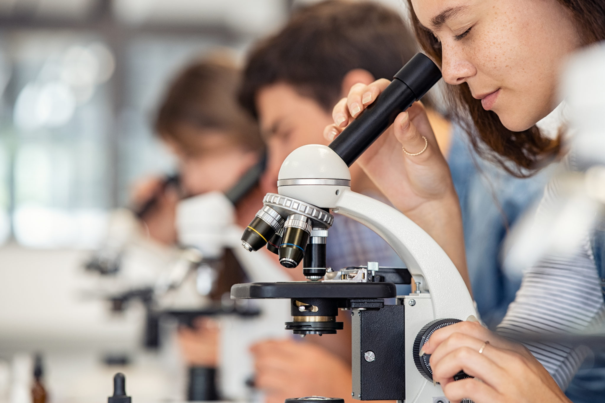 Close,Up,Of,Young,Woman,Seeing,Through,Microscope,In,Science