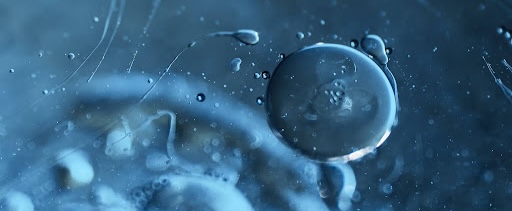 An extreme close‑up, abstract microscopic view showing a single egg cell surrounded by fluid, with several sperm cells surrounding it, illustrating the moment human life begins at conception.